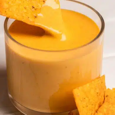 corn chip dipping into a nacho cheese sauce with hidden vegetables